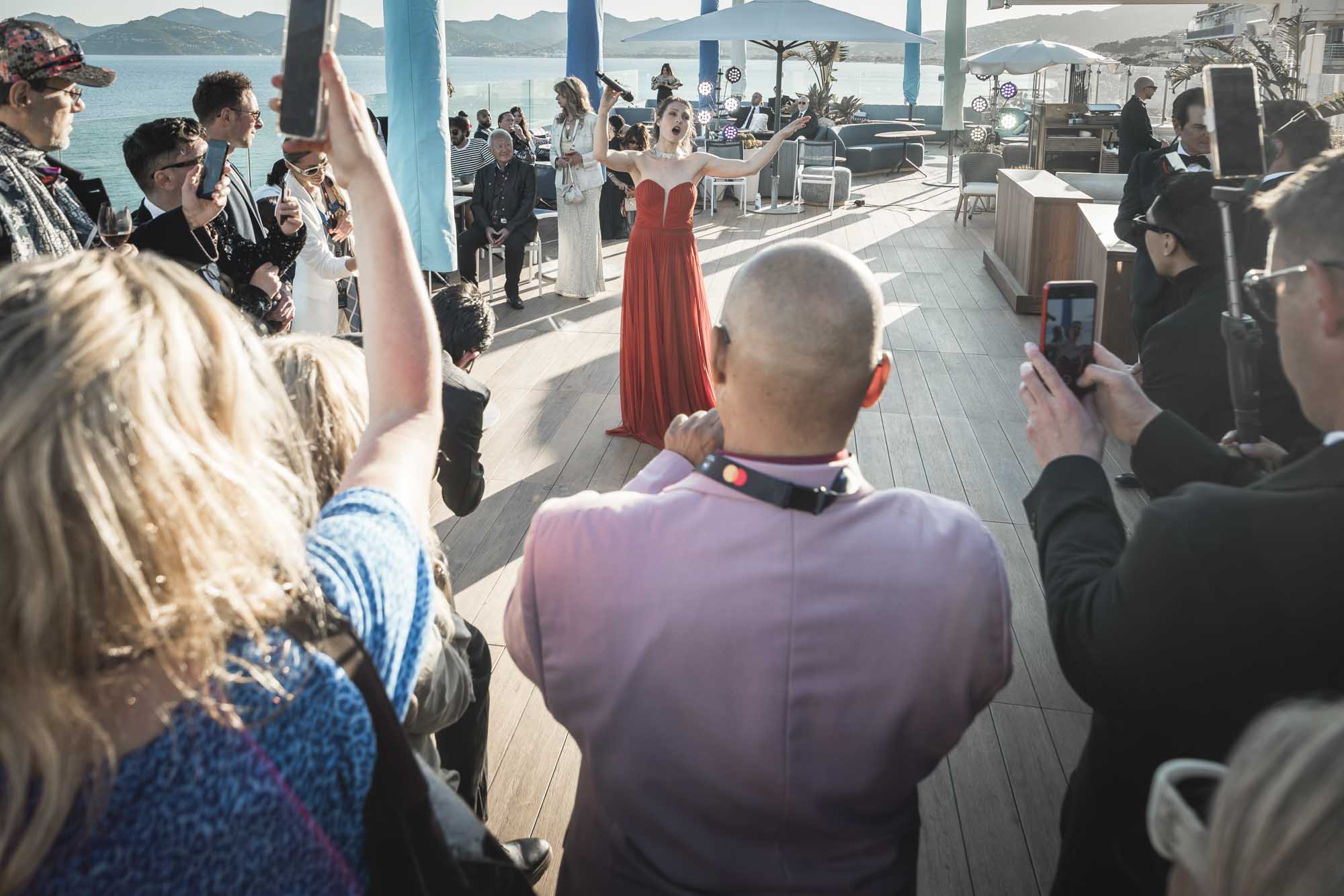Nicole Tschaikin singt im roten Kleid vor Publikum bei der Cannes Global Short Film Awards Gala